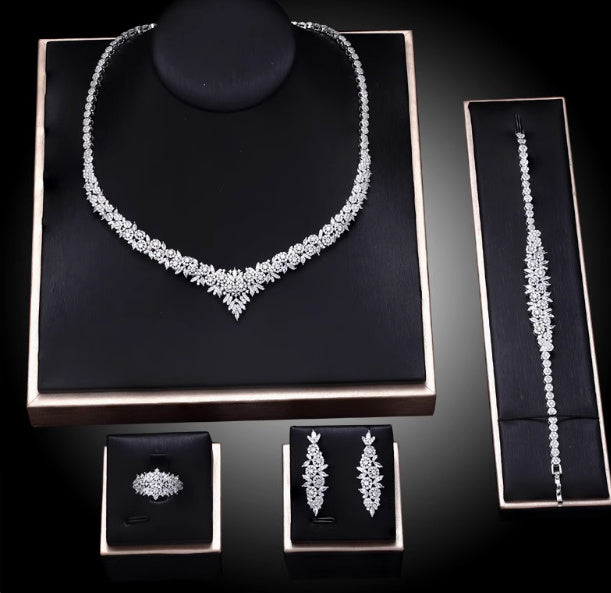 Diamond jewelry set including necklace, bracelet, ring, and earrings on a black background
