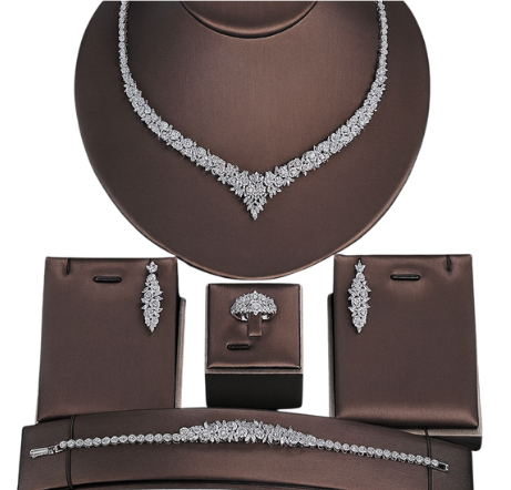 Jewelry set including necklace, earrings, and bracelet on a brown stand.