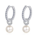 Silver hoop earrings with pearl drops on a white background
