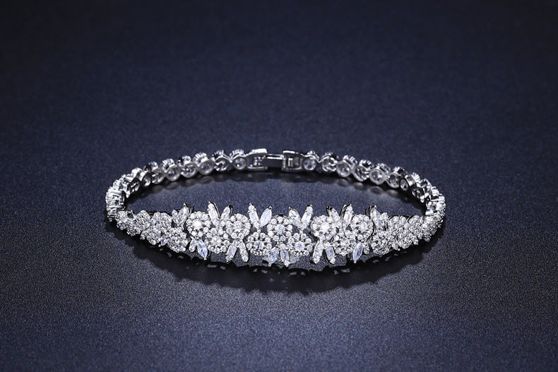 Silver bracelet with floral design on a dark background